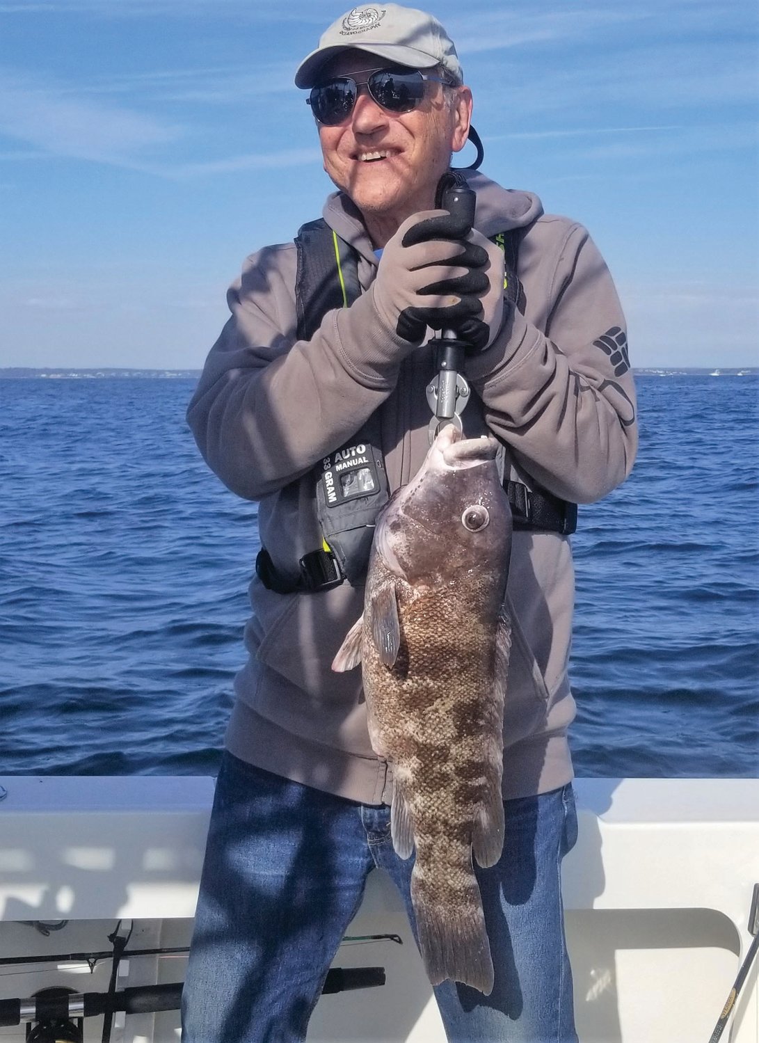 TAUTOG JUNKIES:  Chris Deacutis, North Kingstown, with a 23-inch tautog he caught fishing with Hal Walker, Wakefield and Walt Galloway, West Greenwich. They trio caught their ten fish boat limit in three hours.